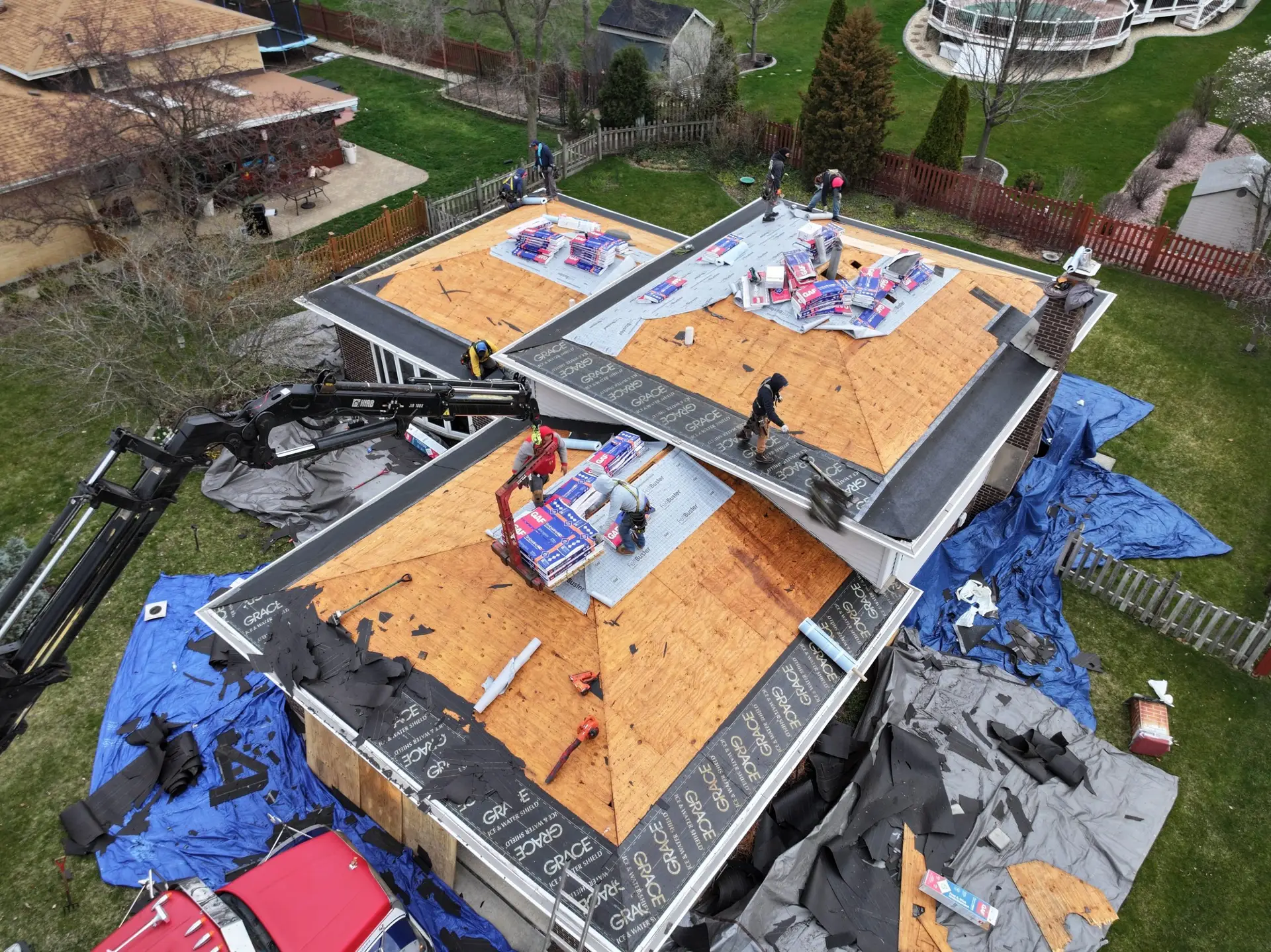 Drone view of an active roof tear off with Grace Ice and Water Shield installed and a crane on site