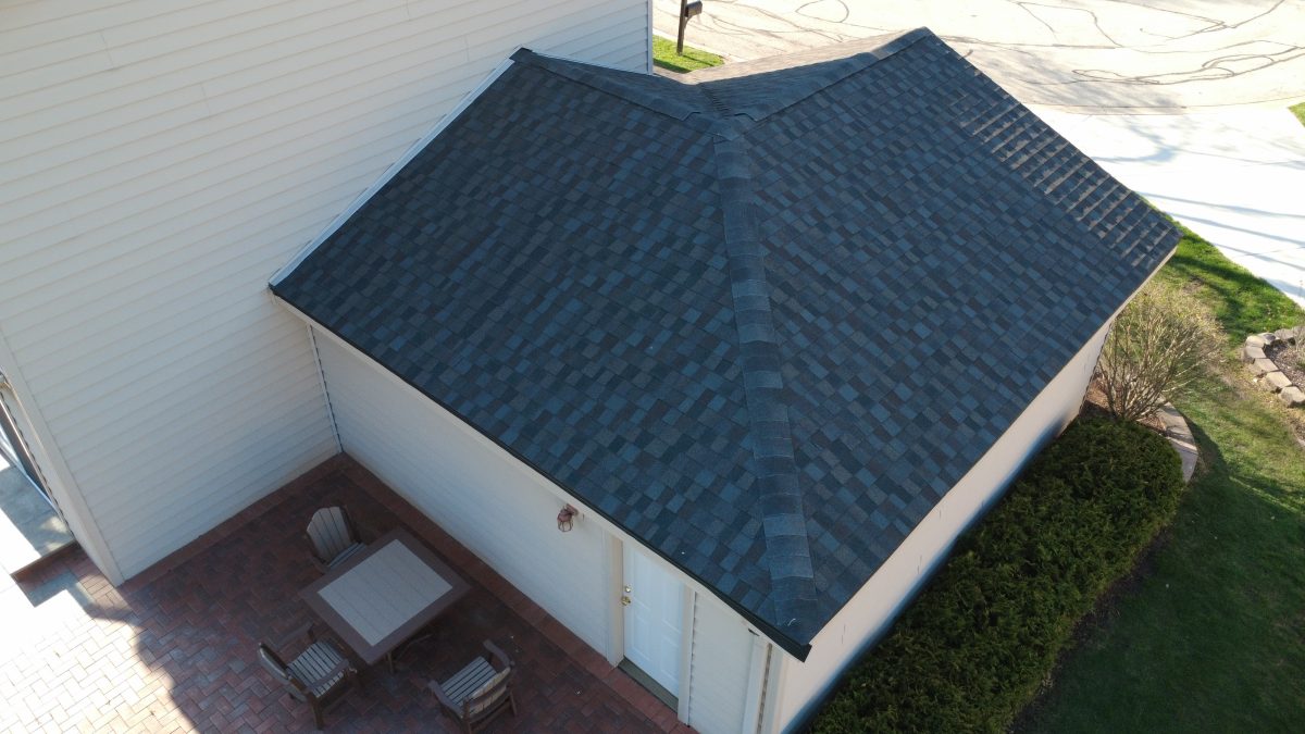 lose-up aerial view of a newly installed dark gray asphalt shingle roof on a residential garage.