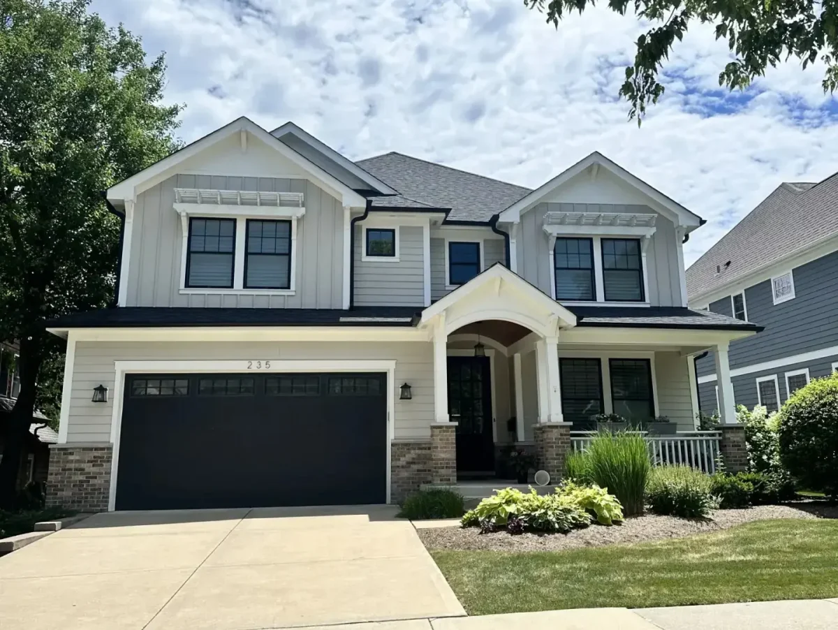 Modern craftsman home with white board-and-batten siding, dark asphalt shingle roof, and covered front porch