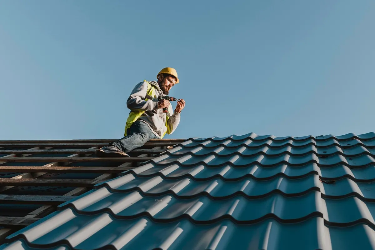 A man working on a roof, emphasizing the importance of hiring skilled roofing professionals.