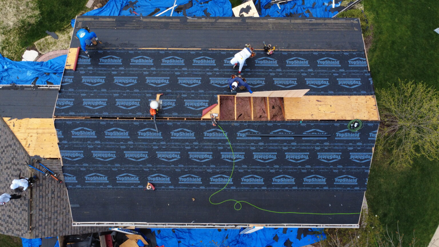 Roofing crew installing asphalt shingles and leak barriers on a Downers Grove home, showing proper technique and materials built for Midwest weather.