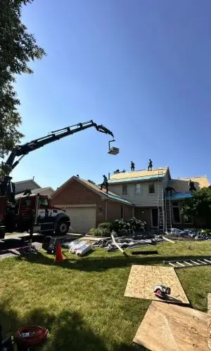 Roof replacement in Downers Grove with crane lifting materials onto home