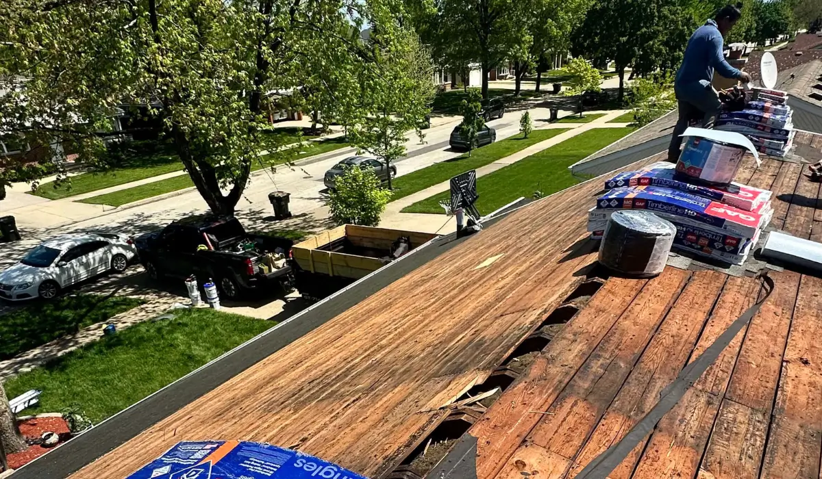 A worker from the best roofing company Downers Grove installs shingles during a roof replacement, ensuring high-quality materials and expert craftsmanship.