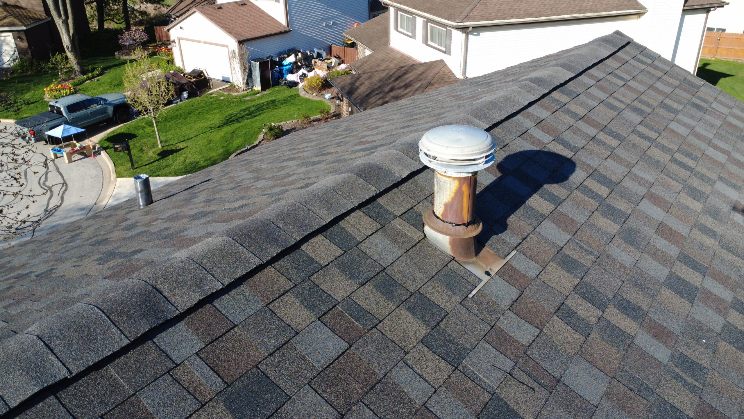 Close-up view of a residential roof with new asphalt shingles and a roof vent.