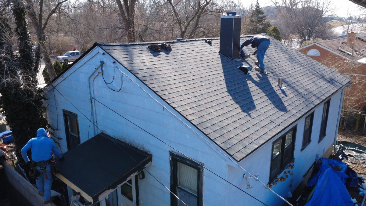 Roofing contractors installing new asphalt shingles on a residential home in Downers Grove, IL during a full roof replacement project.