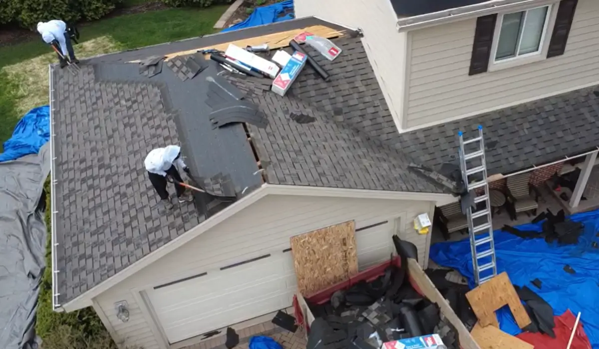 Roofing contractor team in Downers Grove removing damaged shingles during full residential roof replacement.