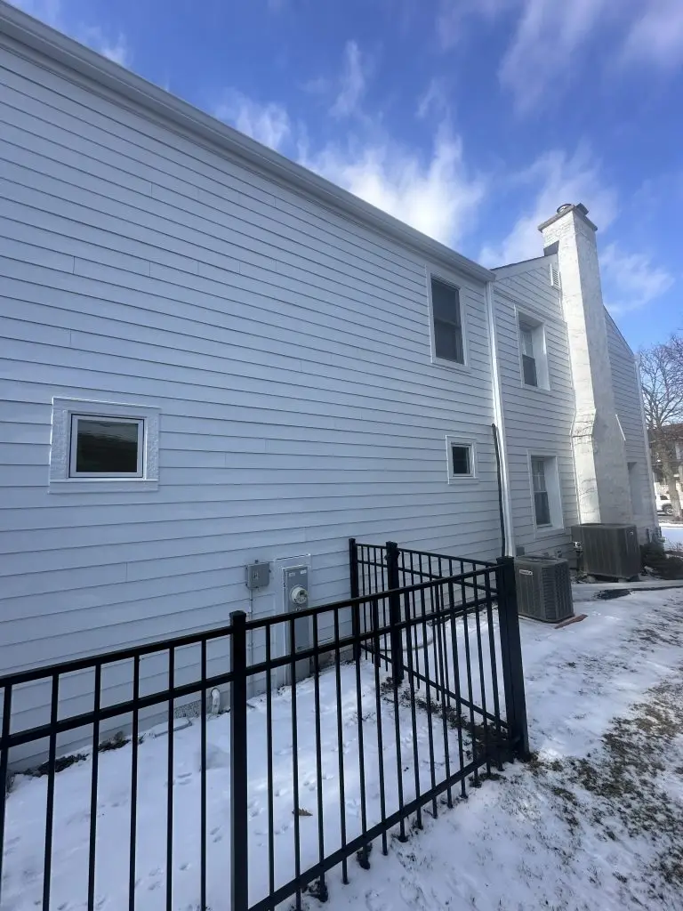 Rear corner of a two-story home after full siding and window replacement