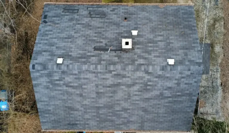 Storm Damage in Hinsdale shown on residential roof with visible repairs, missing shingles, and discoloration patches.