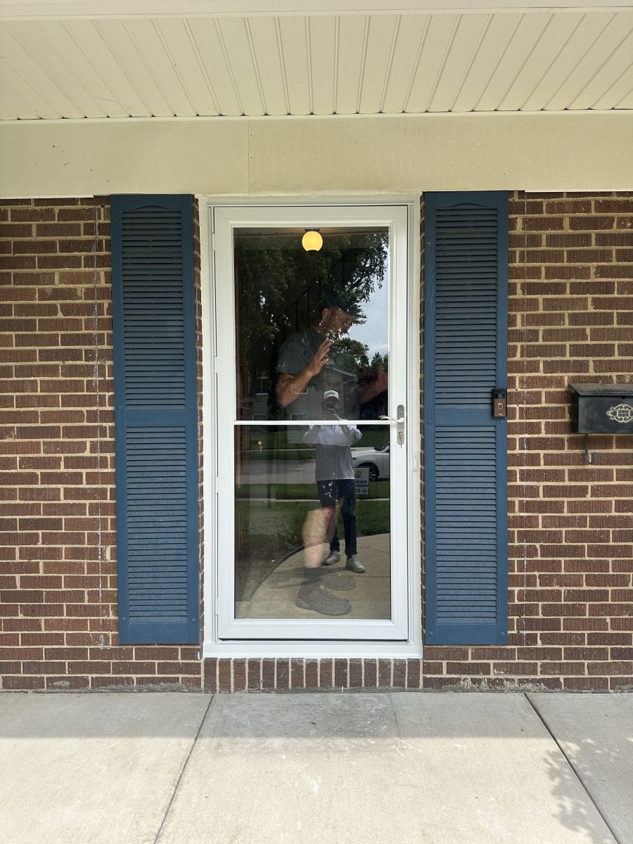Completed white storm door installation on a brick front entry