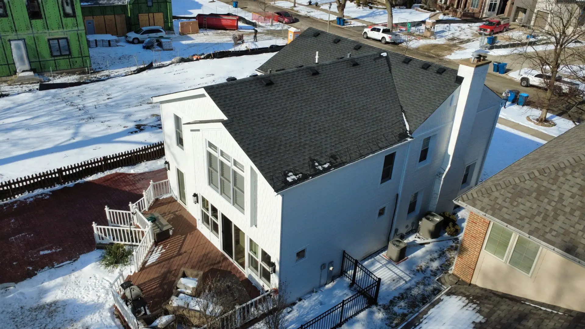 Winter aerial of a new charcoal shingle roof on a newly built modern farmhouse style home